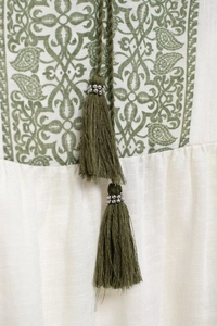 Detail of floral paisley embroidery and tassels on ethnic style linen summer shirt