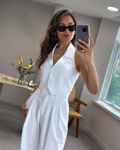 Detailed view of white halter vest and wide-leg trousers suit with sleek satin finish