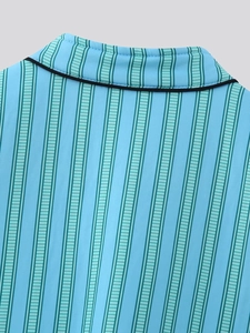 Detail of blue striped vest with black piping and green vertical lines on smooth fabric