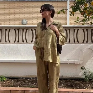 Dettaglio del set jacquard verde oliva con camicia e pantaloni in tessuto satinato