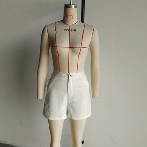Detailed view of high-waist white cotton shorts featuring side pockets and button closure