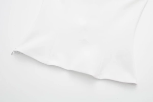Detailansicht des nahtlosen verdeckten Reißverschlusses am weißen Neckholder-Top für Damen