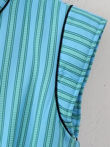 Close-up of sky blue striped fabric with black piping detail and smooth woven texture