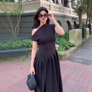 Robe longue noire élégante à une épaule avec jupe plissée et taille cintrée