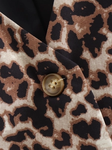 Dettaglio del colletto di un gilet leopardato con trama del tessuto e bottone marrone