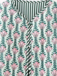 Detail of floral quilted vest with striped lining and fabric covered buttons
