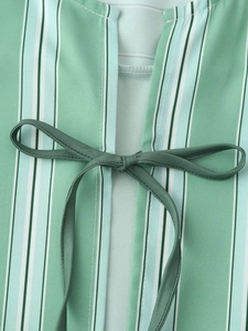Detail of green and white vertical striped fabric with a dark green decorative bow tie