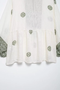 Close-up of ethnic print detail and linen texture on this white summer vacation shirt