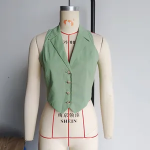 Detail of light green halter vest showing the sharp pointed hem and four-button closure