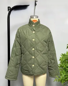 Détail d'une veste matelassée verte à losanges avec col montant et boutons ambre