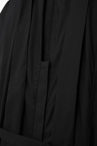 Macro shot of black button-down shirt dress featuring pleated fabric details and collar design