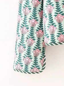Detail of quilted floral cotton jacket with green tulip print and retro trim