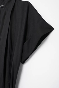 Close-up of the black shirt dress shoulder and collar featuring EFEIR brand woven label