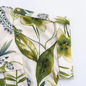 Détail du chemisier imprimé floral avec pattes d'épaule et finitions de boutons fins