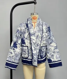 Detail of blue and white Toile de Jouy floral print on quilted jacket with front pockets