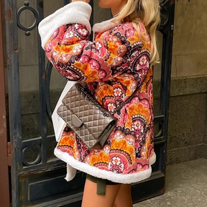 Detail of bohemian floral quilted jacket with plush white faux shearling trim accents