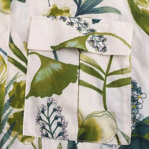 Détail de la poche à rabat à soufflet sur une chemise à imprimé floral et feuillage