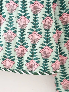 Detailed close-up of quilted floral fabric with vertical stitching and striped edging