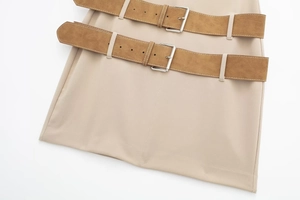 Close-up of beige skirt waist featuring double brown suede belts and silver metal buckles