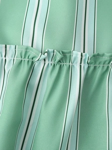 Close-up of blue and green striped fabric with ruffled pleats and fine stitching details