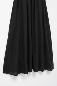 Detail of black dress hem showing breathable fabric texture and invisible side pocket