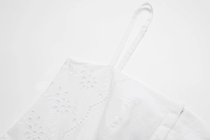 Détail de la broderie florale blanche et des bretelles réglables sur la robe d'été