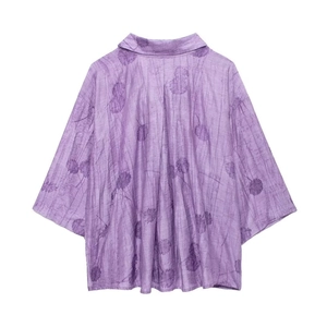 Dettaglio di camicia jacquard viola con trama a pieghe verticali e silhouette rilassata