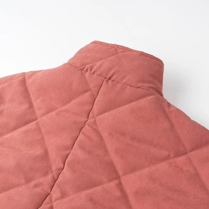 Détail d'une veste matelassée rose à col montant avec texture aspect daim doux
