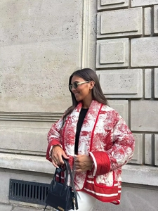 Detail of red and white floral print quilted jacket with contrast piping and pocket detail