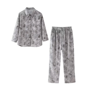 Detailed view of silver satin pajama set with grey abstract leaf patterns and button front