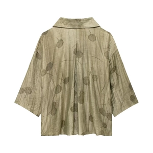 Dettaglio della trama del tessuto a fiori verdi e del taglio ampio del retro camicia