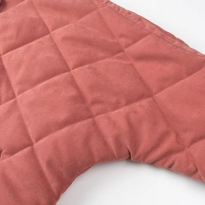 Gros plan détaillé du tissu matelassé à losanges avec coutures sur une veste rose