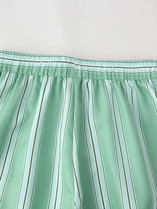 Detail of green and white vertical striped shorts featuring a flexible elastic waistband