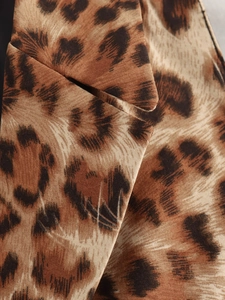 Macro shot of leopard print fabric detail on the neckline of this trendy summer top
