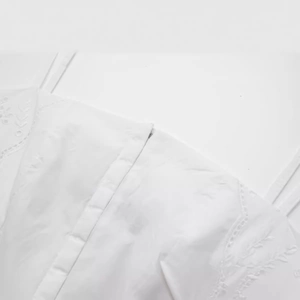 Robe d'été blanche élégante avec broderie de feuilles et boutonnage simple devant