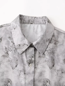 Close-up of grey leaf pattern shirt with silver bead collar detail and white button