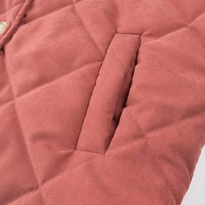 Détail de la veste matelassée rose avec motifs en losanges, poche latérale et texture