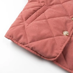 Détail de la veste matelassée à losanges avec bouton marbré et poche latérale pratique