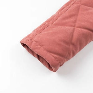 Détail de la manchette matelassée en losanges sur une veste d'hiver rose poudré