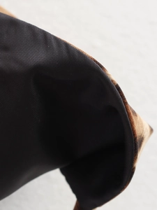 Close-up detail of leopard print fabric with durable black nylon lining and fine stitching