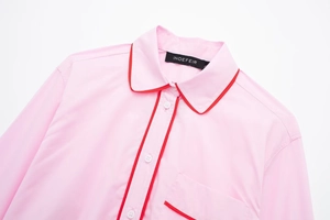 Détail de la chemise rose en popeline avec liseré rouge et boutons en résine blanche