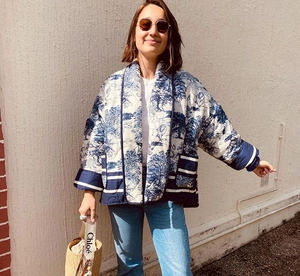 Detailed view of toile de jouy quilted jacket featuring large pockets and navy trim accents