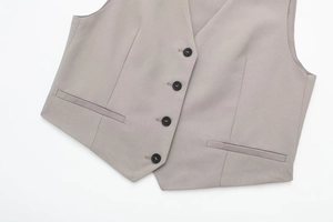 Detail of taupe business vest featuring single-breasted four-button design and welt pockets