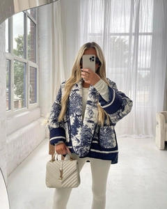 Detail view of blue and white quilted jacket with Toile de Jouy print and navy trim
