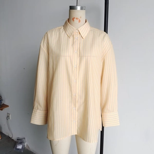 Detail of yellow and light blue vertical striped shirt with classic button-front closure