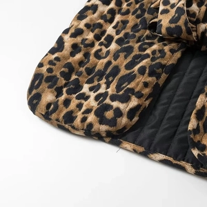 Detailed macro view of quilted leopard print fabric with black lining and premium stitching