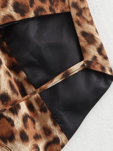 Detailed close-up of leopard print fabric with precise black lining and fine stitching work