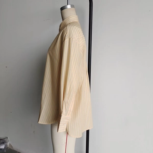Detail of loose-fit striped long-sleeve shirt with classic collar and button cuffs