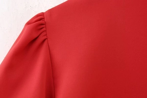 Detailaufnahme der roten Puffärmel mit elegantem Falten-Schulter-Design am Kleid