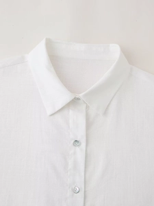 Detail of white linen shirt showing classic collar and lustrous shell-like buttons